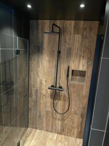 a bathroom with a shower with a wooden wall at Lägenhet Söder om Landsvägen A in Skivarp
