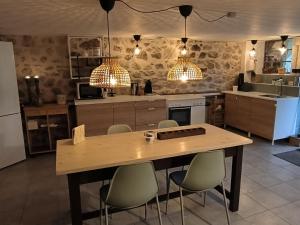 una cocina con una mesa de madera y algunas luces en Chambres d'Hôtes Montjouan en Larochemillay