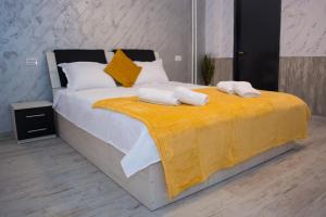una camera da letto con un grande letto con asciugamani di LUXURY ERK a Călimăneşti