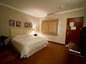 a bedroom with a white bed and a window at Posada El Remanso de Pueblo Nuevo in San Cristóbal