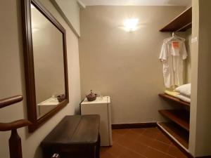 baño con espejo, lavabo y cama en Posada El Remanso de Pueblo Nuevo, en San Cristóbal