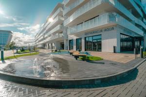 un bâtiment avec une fontaine en face d'un bâtiment dans l'établissement POLANKI AQUA APARTMENTS, à Kołobrzeg