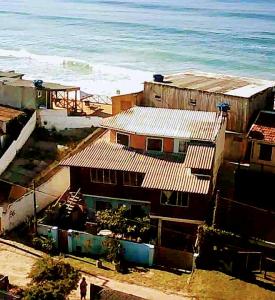 une maison sur la plage à côté de l'océan dans l'établissement Hostel Aroeira do campo, à Florianópolis