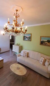 a living room with a couch and a chandelier at Agape casa vacanze in Giardini Naxos