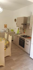 a kitchen with white cabinets and a stove top oven at Agape casa vacanze in Giardini Naxos