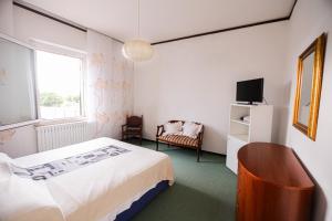 a bedroom with a bed and a tv and a chair at GlampingCashmereHause in Rivotorto 