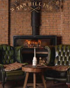 a living room with two leather couches and a fireplace at The Tan Hill Inn in Richmond