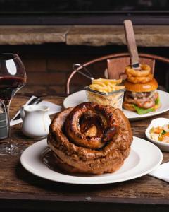 una mesa con dos platos de comida con un sándwich y aros de cebolla en The Tan Hill Inn, en Richmond