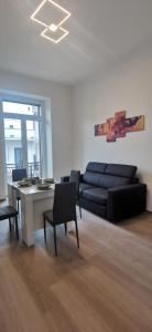 sala de estar con sofá, mesa y sillas en CASA LOSURIELLO, en Triggiano