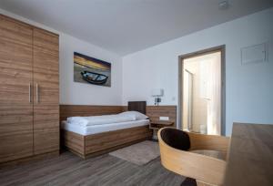 1 dormitorio con cama, escritorio y espejo en Hotel Post Viernheim UG en Viernheim