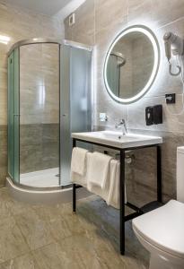 a bathroom with a shower and a sink and a mirror at VATRA HOTEL in Ternopil