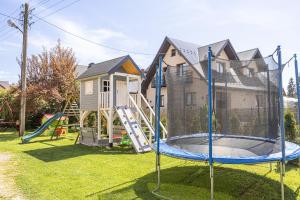 un patio con parque infantil y cama elástica en Czarna Góra Apartamenty TATRY GÓRY BIAŁKA BUKOWINA AGROTURYSTYKA, en Czarna Góra