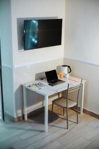 una scrivania con computer portatile e sedia in camera di Reginella a Toledo a Napoli