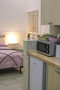 una cucina con forno a microonde su un bancone accanto a un letto di Reginella a Toledo a Napoli