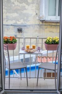 un tavolo e sedie su un balcone con due cesti di fiori di Reginella a Toledo a Napoli