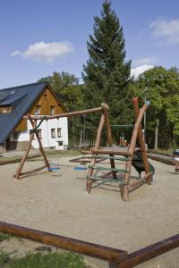 a playground with a wooden swing set in a park at Chata Nisanka in Bedřichov