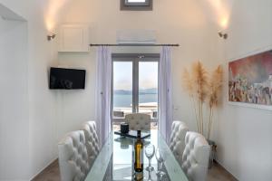 een vergaderzaal met een lange tafel en witte stoelen bij Hemera Holiday Home villa on Santorini in Akrotiri