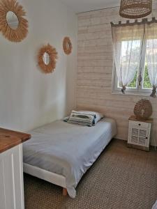 a bedroom with a bed and a window at La Pitchoune in Andernos-les-Bains