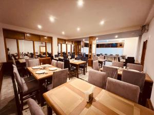 Hill River Resort - Central Heated & Air cooled في مانالي: غرفة طعام مع طاولات وكراسي خشبية