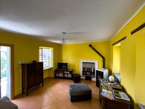 een woonkamer met gele muren en een bank bij La Casetta Gialla in Biella