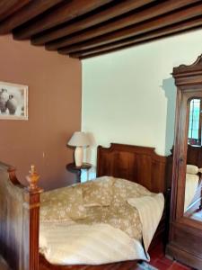 1 dormitorio con 1 cama con marco de madera en La ferme des douceurs, en Cervon
