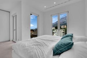 a white bedroom with a large bed with a pillow at Apartment Ocean View in Tučepi