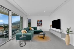 uma sala de estar com um sofá verde e uma televisão em Apartment Ocean View em Tučepi