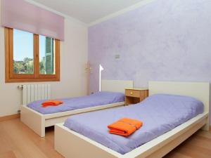 two beds in a bedroom with purple sheets and orange towels at Es Closet in El Port de la Selva +17 photos