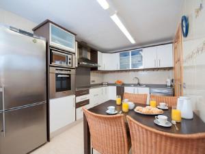 a kitchen with a table and a stainless steel refrigerator at Es Closet in El Port de la Selva