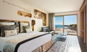 a bedroom with a bed and a view of the ocean at Pure Salt Port Adriano - Adults Only in Santa Ponsa