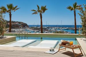 a pool with palm trees and a view of a marina at Pure Salt Port Adriano - Adults Only in Santa Ponsa