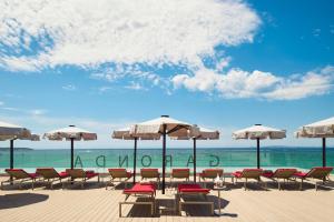 een groep stoelen en parasols op een strand bij Pure Salt Garonda - Adults Only in Playa de Palma