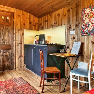 a kitchen with a table and chairs in a room at Under the Oak Glamping in Caerphilly