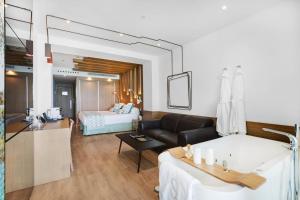 a living room with a bath tub and a bedroom at Pure Salt Garonda - Adults Only in Playa de Palma