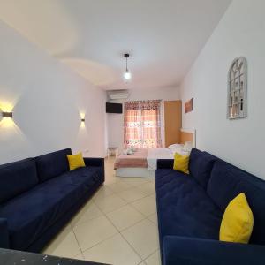 ein Wohnzimmer mit einem blauen Sofa und einem Bett in der Unterkunft Studio by the beach - Vlore in Vlorë