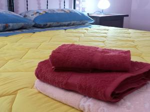 una pila de toallas sentadas encima de una cama en B&B Le Colonne en Montefusco
