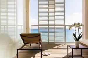 a chair and a table in a room with a large window at Pure Salt Garonda - Adults Only in Playa de Palma