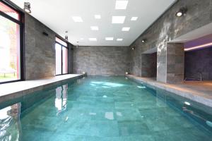 an indoor swimming pool with green tile floors and windows at Pure Salt Garonda - Adults Only in Playa de Palma