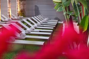 a row of white benches sitting next to a building at Pure Salt Garonda - Adults Only in Playa de Palma
