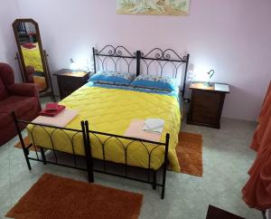 1 dormitorio con 1 cama con sábanas amarillas y almohadas azules en B&B Le Colonne en Montefusco