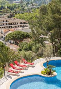 a pool with chaise lounge chairs and a resort at Pure Salt Port de Sóller in Port de Soller
