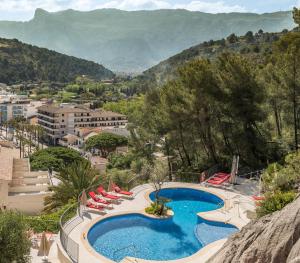 un complejo con piscina, tumbonas y montañas en Pure Salt Port de Sóller, en Puerto de Sóller