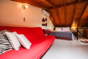 a living room with a red couch and a bed at Delmare Olive beach house II in Yerakiní