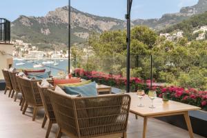 Eine Reihe von Stühlen und Tischen mit Weingläsern auf einem Balkon in der Unterkunft Pure Salt Port de Sóller in Port de Sóller