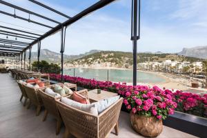 Eine Stuhlreihe auf einem Balkon mit Blumen in der Unterkunft Pure Salt Port de Sóller in Port de Sóller