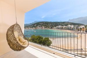 Eine Rattanschaukel hängt von einem Balkon mit Blick auf den Strand. in der Unterkunft Pure Salt Port de Sóller in Port de Sóller + 67 Fotos