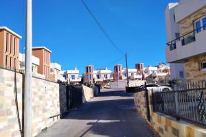 an empty street with white buildings and a fence at Студия для отдыха или проживания in Dobra Voda