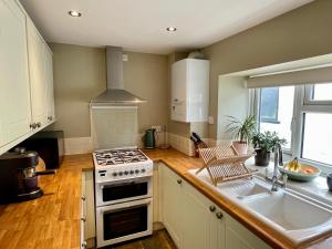 a kitchen with a stove and a sink at Quiet & Cosy 2-Bedroom Cottage in Coltishall in Coltishall