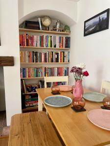 a dining room with a table and a book shelf with books at Quiet & Cosy 2-Bedroom Cottage in Coltishall in Coltishall