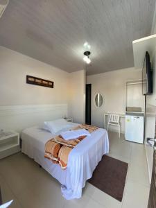 um quarto com uma cama grande e uma cozinha em Pousada Casa do Luiggi em Penha